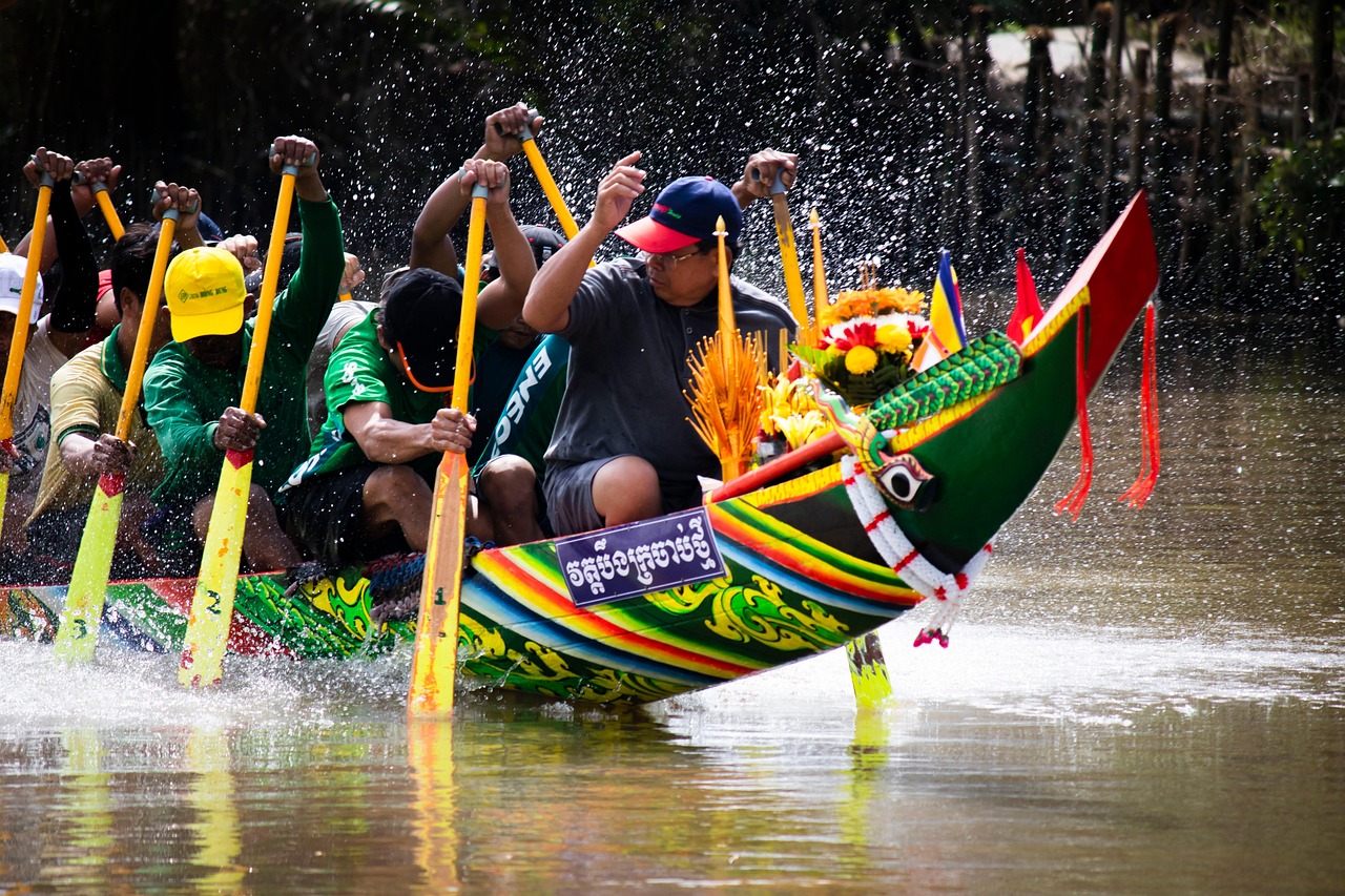 Mũi ghe Ngo sơn sọc xanh, đỏ, vàng, trang trí mâm hoa cúng, các tay chèo cầm mái chèo vàng làm nước bắn tung tóe