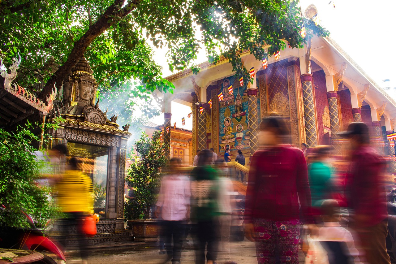 Dòng người đi lễ qua cổng chạm khắc của một ngôi chùa Khmer ở miền Tây, khói nhang lan dưới tán cây lớn trong ngày hội