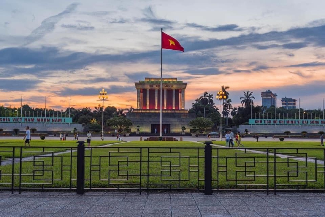 Lăng Chủ tịch Hồ Chí Minh trên Quảng trường Ba Đình, Hà Nội, với lá cờ Tổ quốc tung bay lúc hoàng hôn