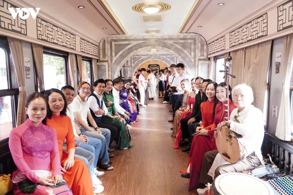 Intérieur d'une voiture du train du patrimoine, voyageurs assis près des fenêtres (photo VOV)