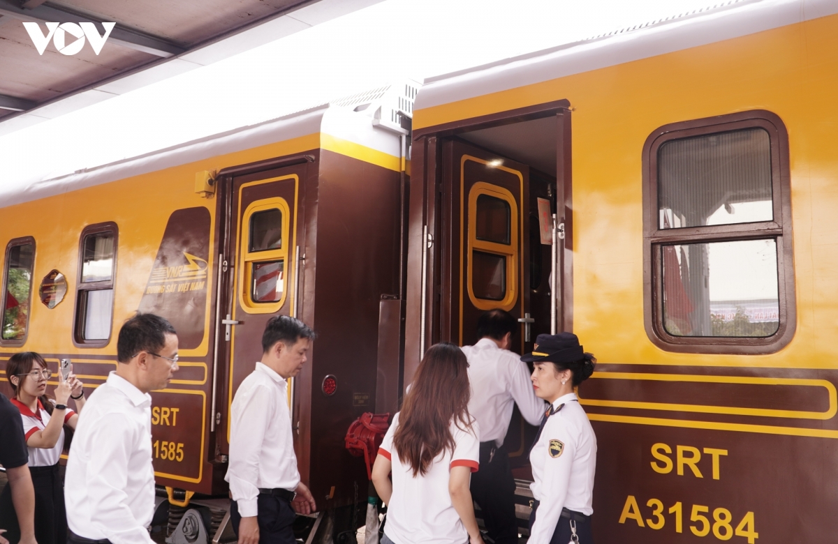 Voiture du train du patrimoine Huế – Phong Nha à quai, avec le personnel de bord (photo VOV)